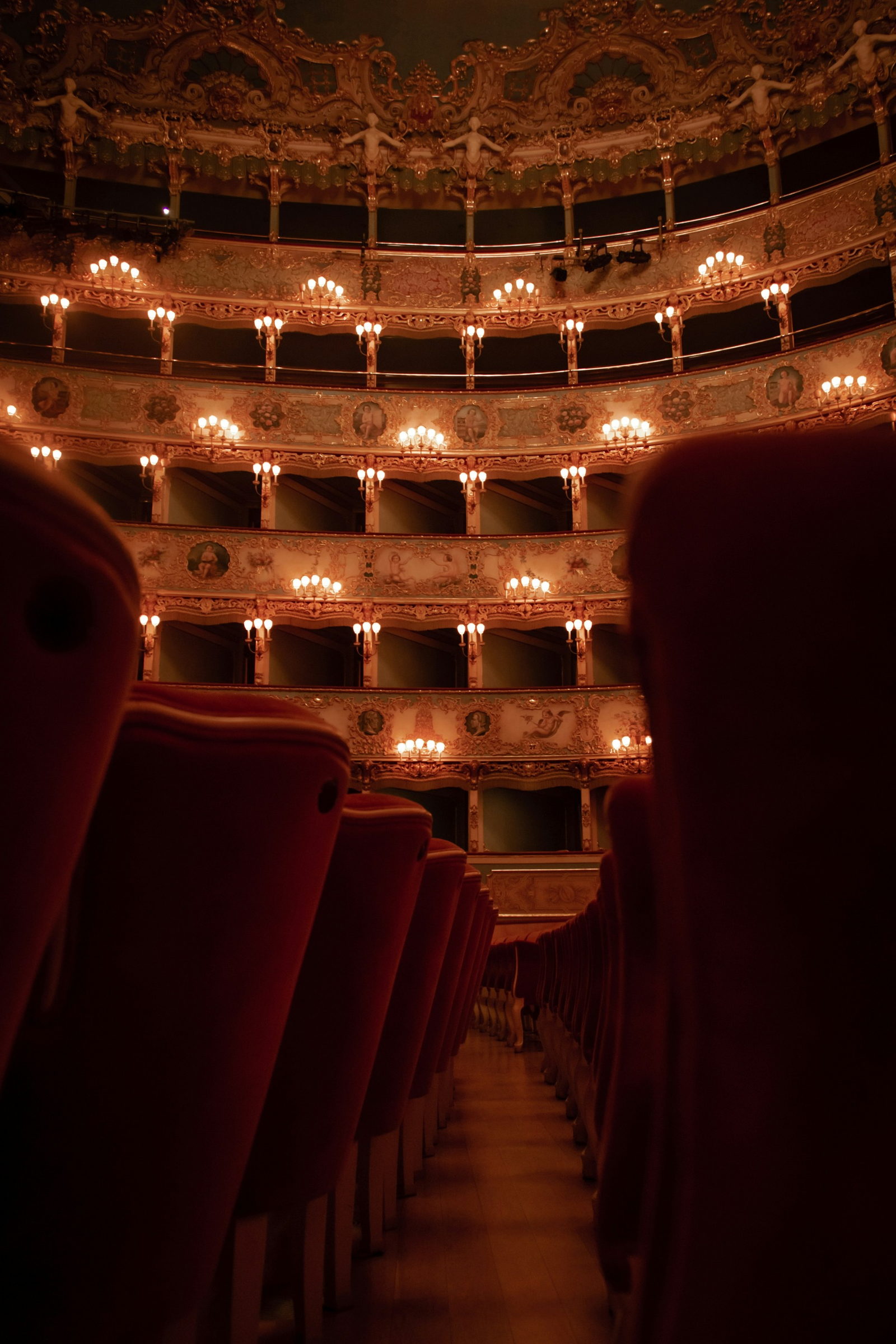 Tiers of opera-house boxes above red velvet seats