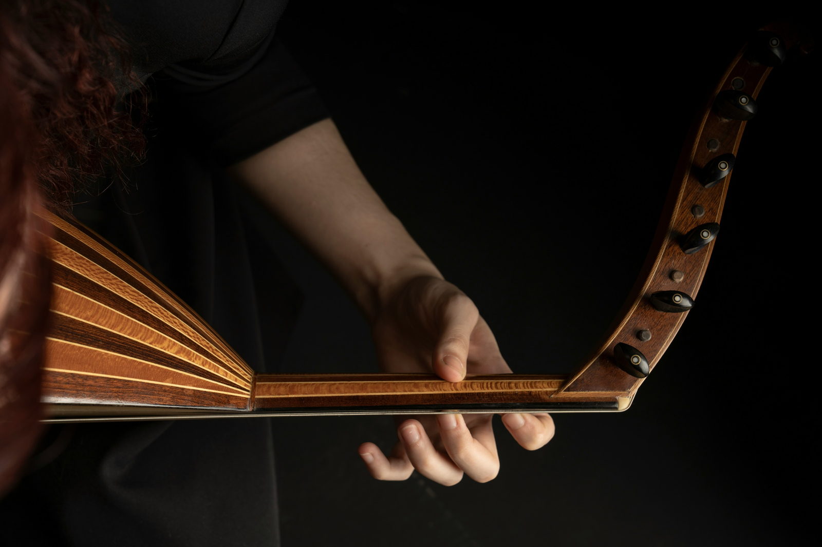 Hands holding an oud, a Middle Eastern lute