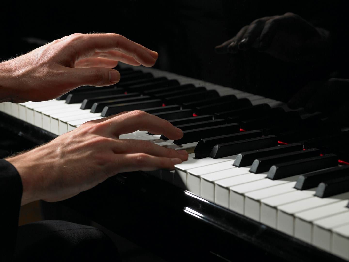 A pianist’s hands playing a grand piano