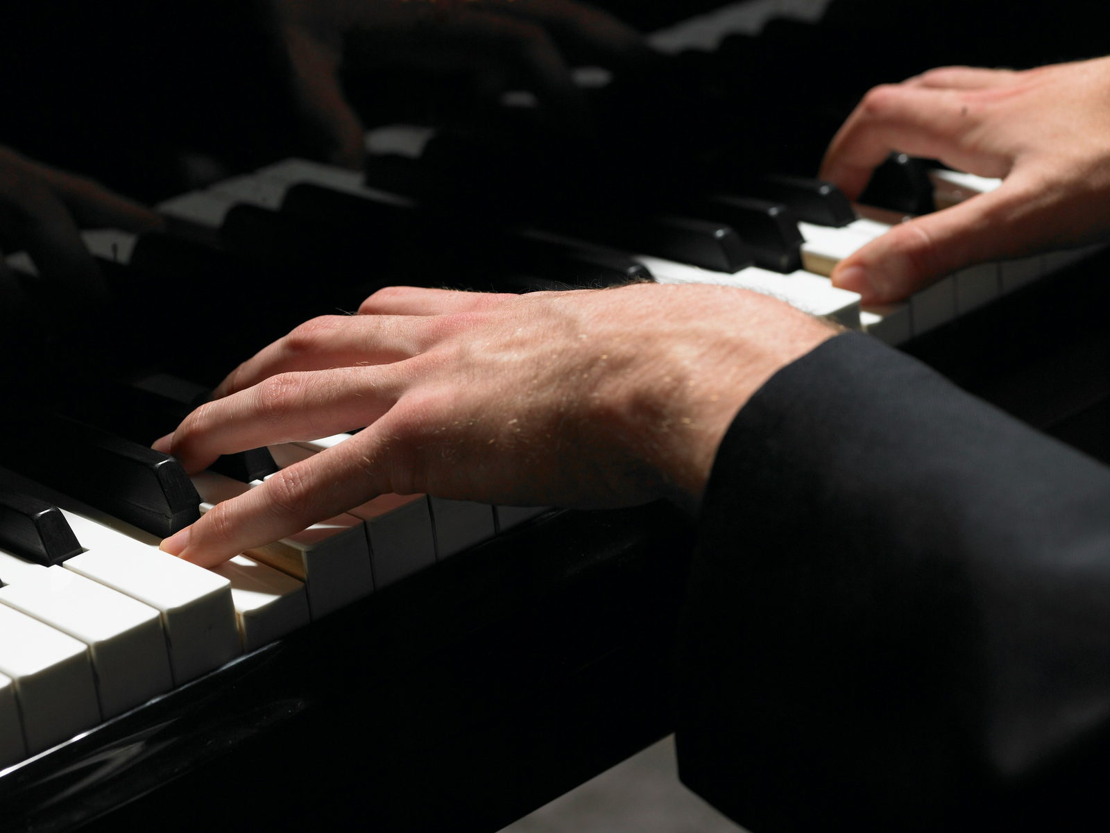 A pianist’s hands on the keys of a grand piano