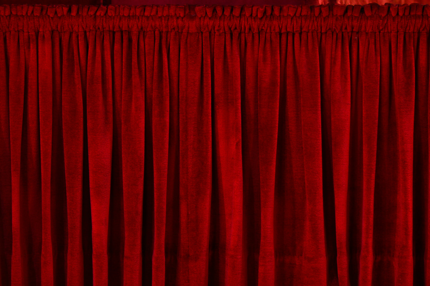 Rich red velvet curtains across a theatre stage